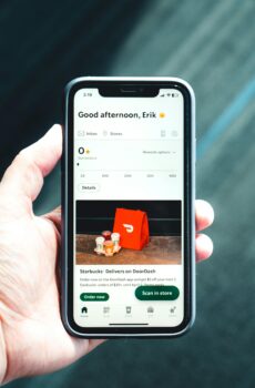 Close-up of a smartphone with a delivery app interface in a person's hand, emphasizing modern e-commerce.